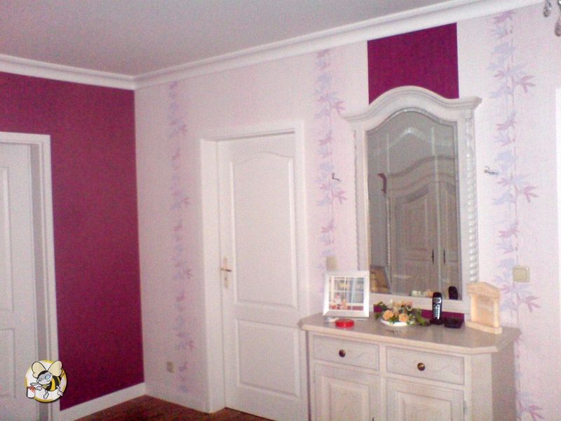 Andere Seite des Raumes mit der Magenta Wand. Diese Wand wird mit einer weißen Tapete, die vertikale florale Muster hat tapeziert und vor einer antiken Speigelkommode ist ein vertikaler Streifen in Magenta