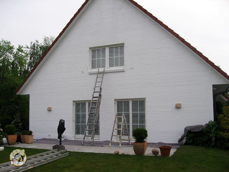 Fassadenanstrich in weiß mit weiß lackierten Fenstern an einem Einfamilienhaus.