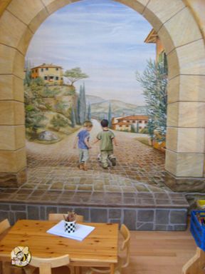 realistische Wandmalerei in einem Innenraum. Zu sehen sind zwei Kinder von hinten, die Hand in Hand eine Straße entlanggehen. Die Malerei fügt sich nahtlos in den Raum ein und schafft die Illusion als würde man durch einen Torbogen genau diese Landschaft vor sich sehen.