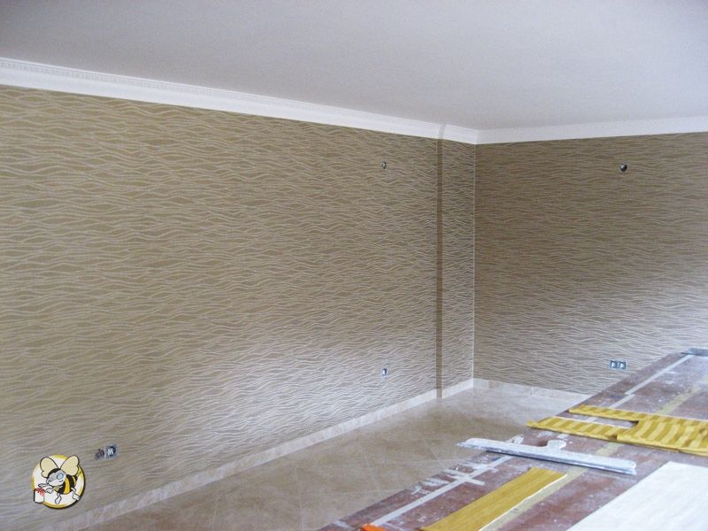 Wandgestaltung eines Innenraumes mit Tapete, die in beigefarben und Wellenmuster das flächig über die ganze Wand geht